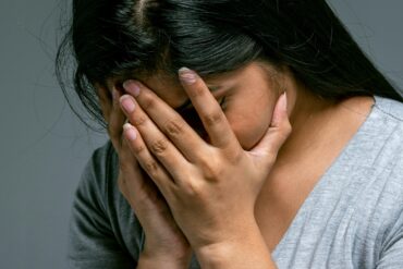Woman Hiding Her Face in Hands