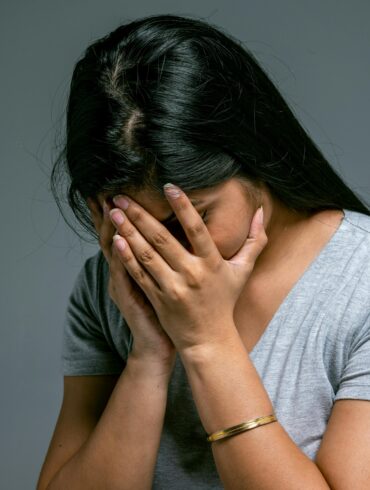 Woman Hiding Her Face in Hands